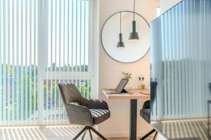 an office with a desk and chairs and a mirror at Stadtloft Penthouse "Eversten" Neubau Business Apartments für Projekt- und Firmenaufenthalte in Oldenburg