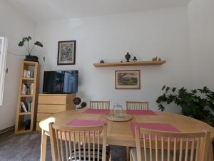 a dining room table with four chairs and a tv at U Bílého Beránka in Děčín