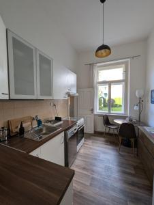a kitchen with white cabinets and a table and a window at U Bílého Beránka in Děčín +13 photos