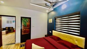 a bedroom with a red bed and a blue wall at Villa Cresta with Outdoor & Indoor pool 3bhk in Vayittiri +19 photos