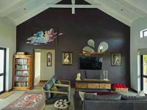 a living room with a couch and a tv at Klawerjas Flute Cottage in Robertson