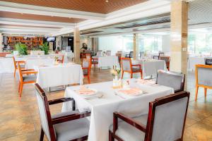 a dining room with white tables and chairs at Swiss Lenana Mount Hotel in Nairobi