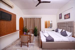 a bedroom with a bed and a table and a tv at Hotel Film Suites in Hyderabad
