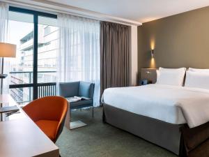 Una habitación de hotel con una cama grande y una ventana. en Pullman Paris Tour Eiffel, en París