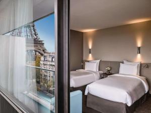 Una cama o camas en una habitación de Pullman Paris Tour Eiffel 43 fotos más