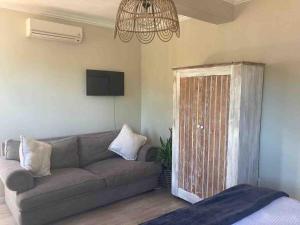 a living room with a couch and a chandelier at Studio Room Durban North in Durban