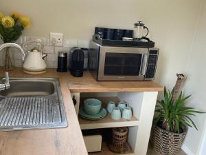 a kitchen counter with a microwave on top of it at Studio Room Durban North in Durban