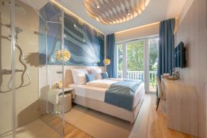 a bedroom with a king sized bed and a shower at Golf 'n Wave Aktivresort Fehmarn in Fehmarn +93 photos