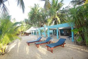 a group of blue chairs sitting in front of a building at Ocean Soluna Beach Villa in Tangalle