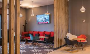 a waiting room with red chairs and a table at Noxi Hotel in Sétif +17 photos