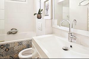 a white bathroom with a sink and a toilet at Charmante maison de ville aux portes de Paris in Suresnes