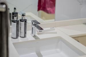 a bathroom sink with two bottles on a counter at 2BR Private Apartment in Al Zahia Sharjah - Wood house in Sharjah