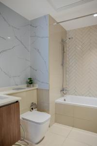 a bathroom with a toilet and a tub and a sink at 2BR Private Apartment in Al Zahia Sharjah - Wood house in Sharjah