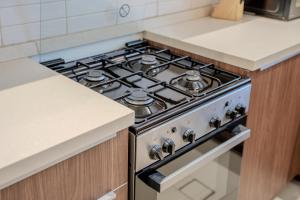 a stove top oven in a kitchen next to a counter at 2BR Private Apartment in Al Zahia Sharjah - Wood house in Sharjah +104 photos