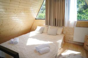 a bedroom with a bed with two towels on it at your dream cottage in Ts'ikhisdziri