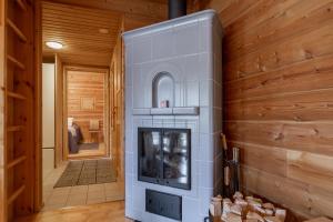 a fireplace in a room with wooden walls at Lomapolku 7 A in Ylläs