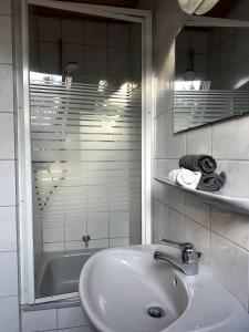 a white bathroom with a sink and a shower at Ferienwohnung am Brombachsee FeWo Horlacher in Pleinfeld