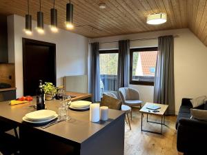 a kitchen and living room with a table and a dining room at Ferienwohnung am Brombachsee FeWo Horlacher in Pleinfeld