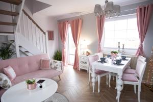 a living room with a pink couch and a table at MarinaMar Karwia in Sławoszynko