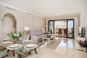 ein Wohnzimmer mit Tisch und Couch in der Unterkunft The Luxury Golf Paradise in Málaga