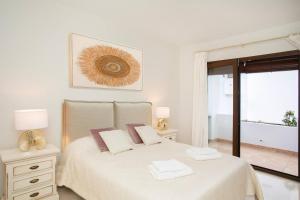 ein weißes Schlafzimmer mit einem Bett und einem Fenster in der Unterkunft The Luxury Golf Paradise in Málaga + 17 Fotos