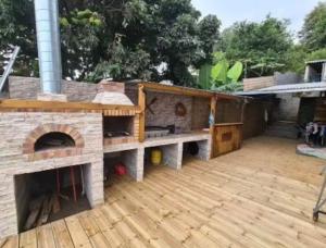 a large outdoor patio with a pizza oven at Maison des Ramiers in Saint-Paul