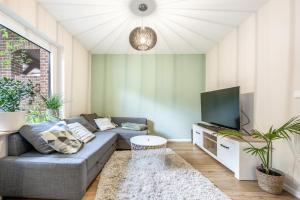 ein Wohnzimmer mit Couch und Flachbildfernseher in der Unterkunft Gemütliches kleines Haus mit 3-4 Schlafplätzen in Ritterhude