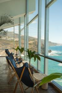 a dining room with a table and chairs and the ocean at Precise Resort Tenerife in Puerto de la Cruz