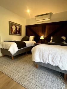 a bedroom with two beds and a large headboard at The Dairy character-filled farm stay in Eumundi +21 photos