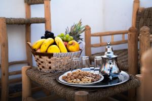 une table avec un panier de fruits et une assiette de noix dans l'établissement Surf & Sun Apartment in Imsouane, à Imsouane