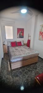 une chambre avec un grand lit avec des oreillers rouges dans l'établissement SunRise Den, a pie de playa, vista al mar y piscina, à El Alamillo 22 autres photos