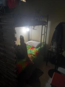 a person sitting in a dark room with a bunk bed at Sweden Inn Hostel Chalong in Ban Klang