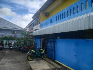a group of motorcycles parked next to a blue building at Sweden Inn Hostel Chalong in Ban Klang