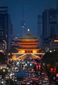 a chinese building with traffic in a city at night at Xi You Hotel禧又 - near Xi'an City Wall, Daming Palace, with ticket service for featured scenic spots ,Paid Airport shuttle and tour charter services available,Welcome gifts and a cup of freshly ground coffee in Xi'an