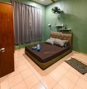 una camera da letto con un letto con un orsacchiotto sopra di Homestay CgSu D'Ria Mesra 2 a Kampong Padang Bungor