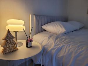 a bed with a table and a lamp next to a bed at Mi casa in Seoul