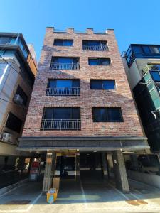 a tall brick building with windows on a street at Mi casa in Seoul