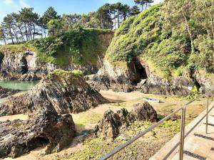 a cave in the side of a hill with rocks at The Cliffs - Cala Porto do Val in O Vicedo