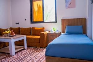 une chambre avec un lit et un canapé dans l'établissement Surf & Sun Apartment in Imsouane, à Imsouane