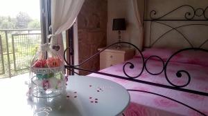 a bedroom with a pink bed with a jar of roses at Antico Casale Fabrizi in Velletri