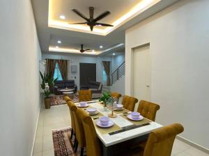 a dining table and chairs in a living room at Homestay in Ayer Molek Malacca in Melaka