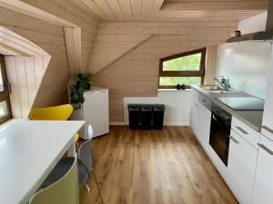 a kitchen in a tiny house with wooden walls at Moderne Monteur- und Ferienwohnung am Plettenberg in Dotternhausen