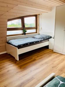 a bedroom with a bed in a room with wood floors at Moderne Monteur- und Ferienwohnung am Plettenberg in Dotternhausen