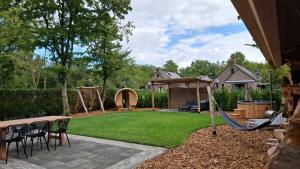 a backyard with a swing set and a playground at Groene heuvels 101 in Ewijk