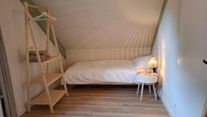 a small bedroom with a bed and a ladder at Groene heuvels 101 in Ewijk