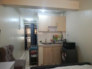 a small kitchen with wooden cabinets and a sink at Zuri studio in Kinoo