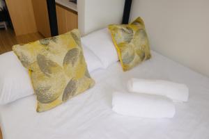 a white bed with two pillows and a towel on it at Cozy Davao Studio with Queen and Bunk Bed Near Abreeza Mall in Davao City