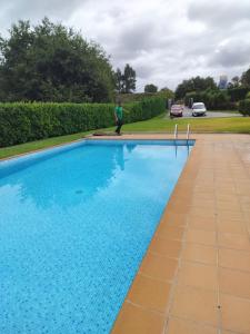 ポンテ・ダ・バルカにあるPegadinha House - Uchillの大きなスイミングプールの横に立つ男
