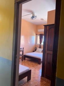 een kamer met een slaapkamer met een bed en een bank bij Le Paradisier Hotel Restaurant in Antsohihy