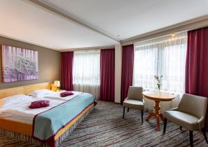 Una habitación de hotel con una cama, una mesa y sillas. en Hotel Pelikan, en Schwäbisch Gmünd